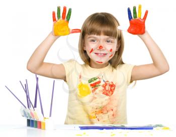 Portrait of a cute cheerful girl showing her hands painted in bright colors, isolated over white