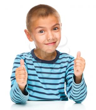 Portrait of a cute boy showing thumb up sign using both hands, isolated over white