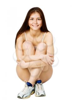 Royalty Free Photo of a Girl Sitting on the Floor Wearing Sneakers