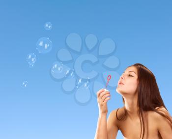 Royalty Free Photo of a Girl Blowing Soap Bubbles