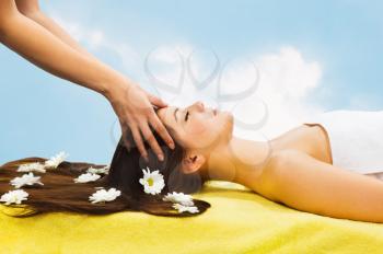 Royalty Free Photo of a Woman Getting a Scalp Massage With Daisies on Her Hair