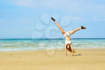 Royalty Free Photo of a Girl Doing Cartwheels on the Beach