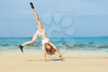 Royalty Free Photo of a Girl Doing Cartwheels on the Beach