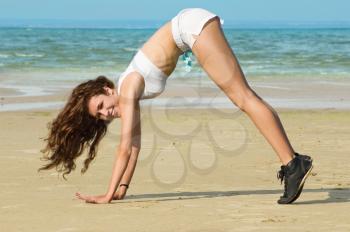 Royalty Free Photo of a Woman Stretching at the Beach