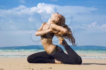 Royalty Free Photo of a Woman Stretching on the Beach