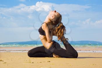 Royalty Free Photo of a Woman Doing Yoga on the Beach