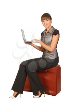 Royalty Free Photo of a Woman on a Suitcase With a Laptop
