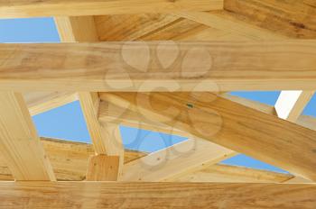 Fragment of a new residential construction home framing against a blue sky.