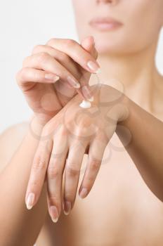 Woman hands applying moisturizing cream to her skin.Shallow focus