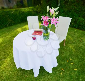 an empty wedding ceremony table at the park on grass