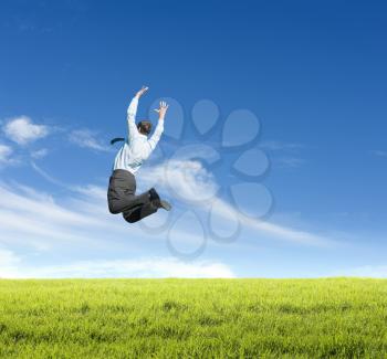 happy young man jumping on meadow against clear sky background