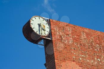 old and broken town clock and brick wall