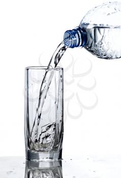 fresh water being poured into a  glass isolated on white 