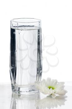 Glass of fresh water with flower isolated on white