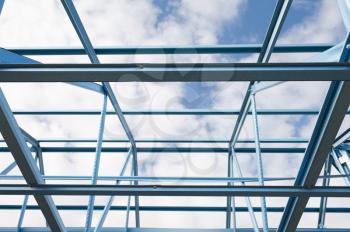 New residential construction home metal framing against a blue sky.Fragment.
