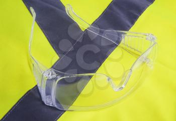 Yellow vest and protection glasses close up
