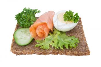 whole grain rye bread sandwich with salmon, egg and vegetables, isolated