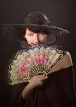   Portrait of a young  pretty woman with fan



