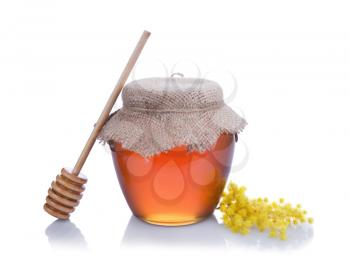Honey with wood stick and flowers isolated on white background