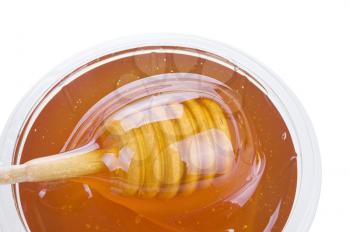 glass jar with honey and wooden stick isolated on white background 