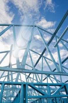 New home under construction using steel frames against a sunny sky.