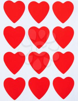 dozen of red hearts on the paper as background