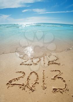 digits  2012 and 2013 on the sand seashore - concept of new year