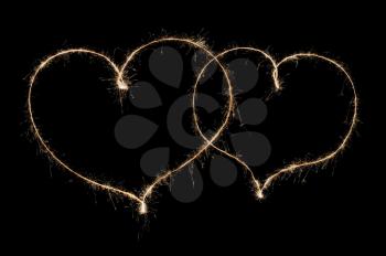two hearts from sparkler isolated on black background
