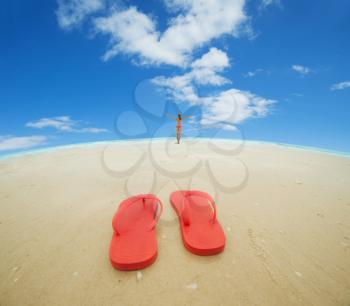 Red flip flops and female silhouette on the beach.Concept of summer vacations