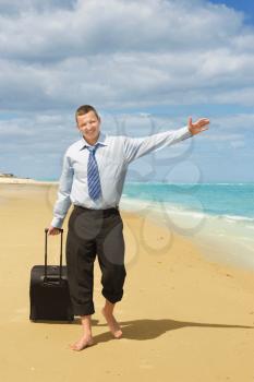 Businessman walking on the beach the first day of vacation