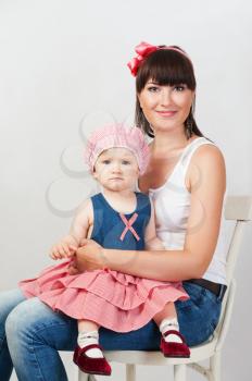 Beautiful happy mother with baby daughter on white background 