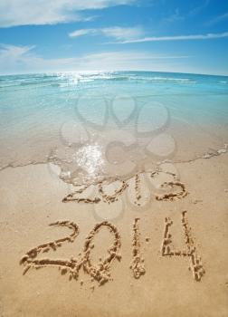 digits  2013 and 2014 on the sand seashore - concept of new year