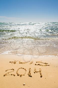digits  2013 and 2014 on the sand seashore - concept of new year and passing of time