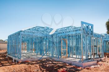 New home under construction using steel frames against blue sky