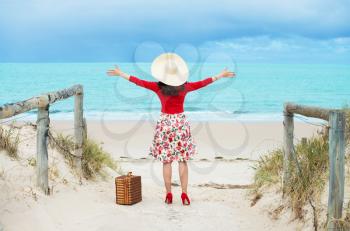 beautiful woman traveler in retro style dress  on the beach