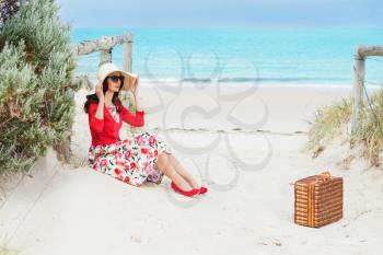 beautiful lady in red  sitting near the sea in retro style