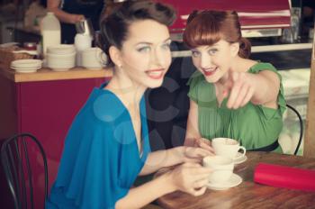 Two beautiful girls in retro style in retro cafe