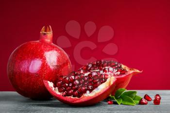 Juicy pomegranate fruit with leaves  on a red background