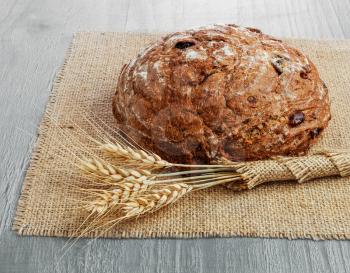 loaf of  sour cherry and walnut rye bread on wooden background 