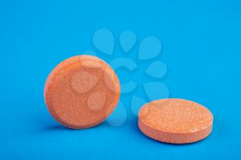 two orange tablets on a blue background
