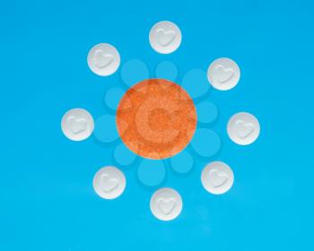 white and orange pills on a blue background 