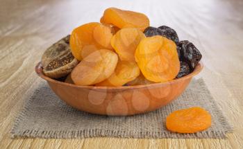 Dried pitted fruits on a wooden background 