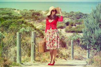 beautiful lady in red traveler  on the beach  in retro style