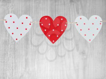 Three Valentines Day hearts on vintage wooden background as Valentines Day  symbol