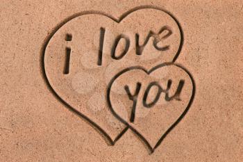 Two Hearts and message I Love You imprint on the sand