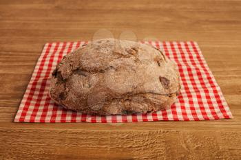 loaf of  sour cherry and walnut rye bread on wooden background 