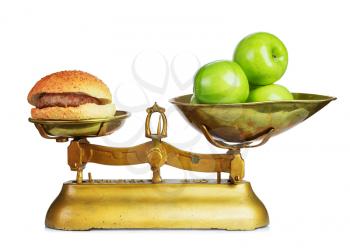 Healthy food and unhealthy food on old retro scales.Dieting concept.Isolated.