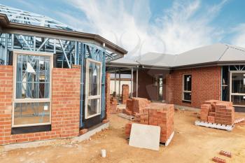 New residential construction home from brick with metal framing against a blue sky
