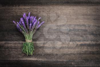 bundle of lavender flowers on on vintage wooden background 