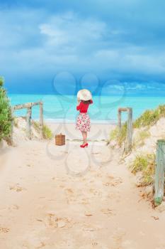 beautiful woman traveler in retro style dress  on the beach and dunes